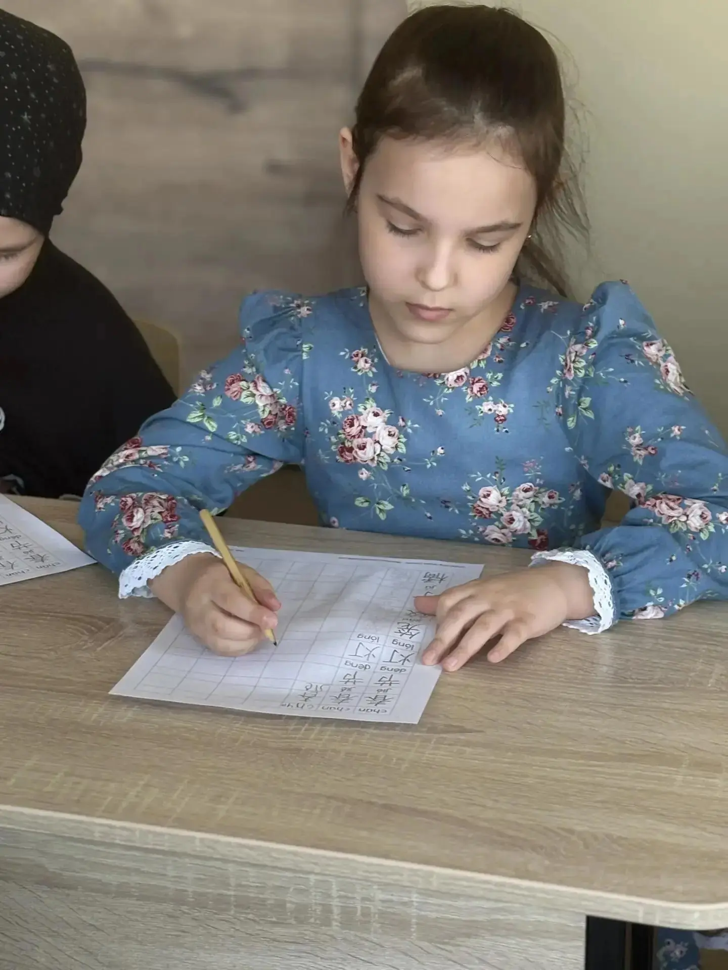 Ученица пишет за партой на продлёнке